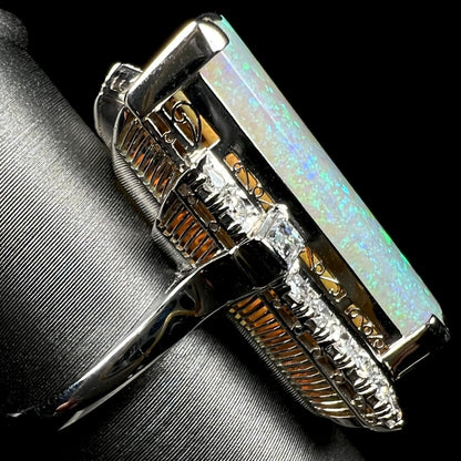 A vintage Japanese platinum cocktail ring with architectural Art Deco-inspired basket design featuring Australian light opal and diamonds, shown from side view.