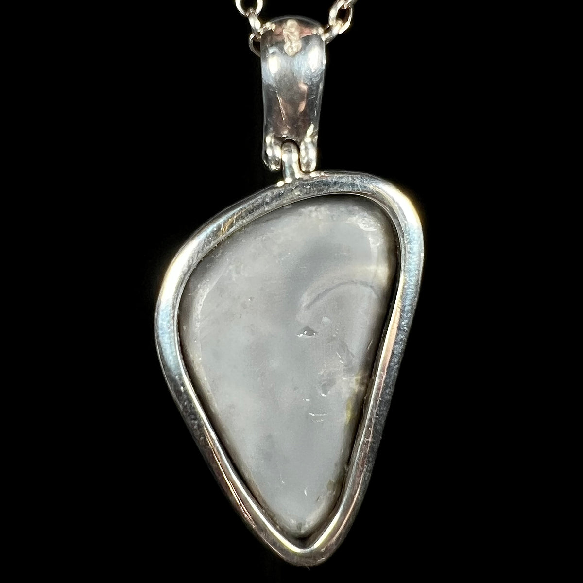 Back side of Australian black opal pendant showing gray potch in open-back sterling silver bezel design