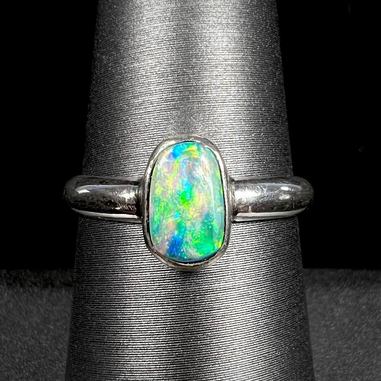 Handmade silver Australian crystal opal solitaire ring shown close-up on ring display