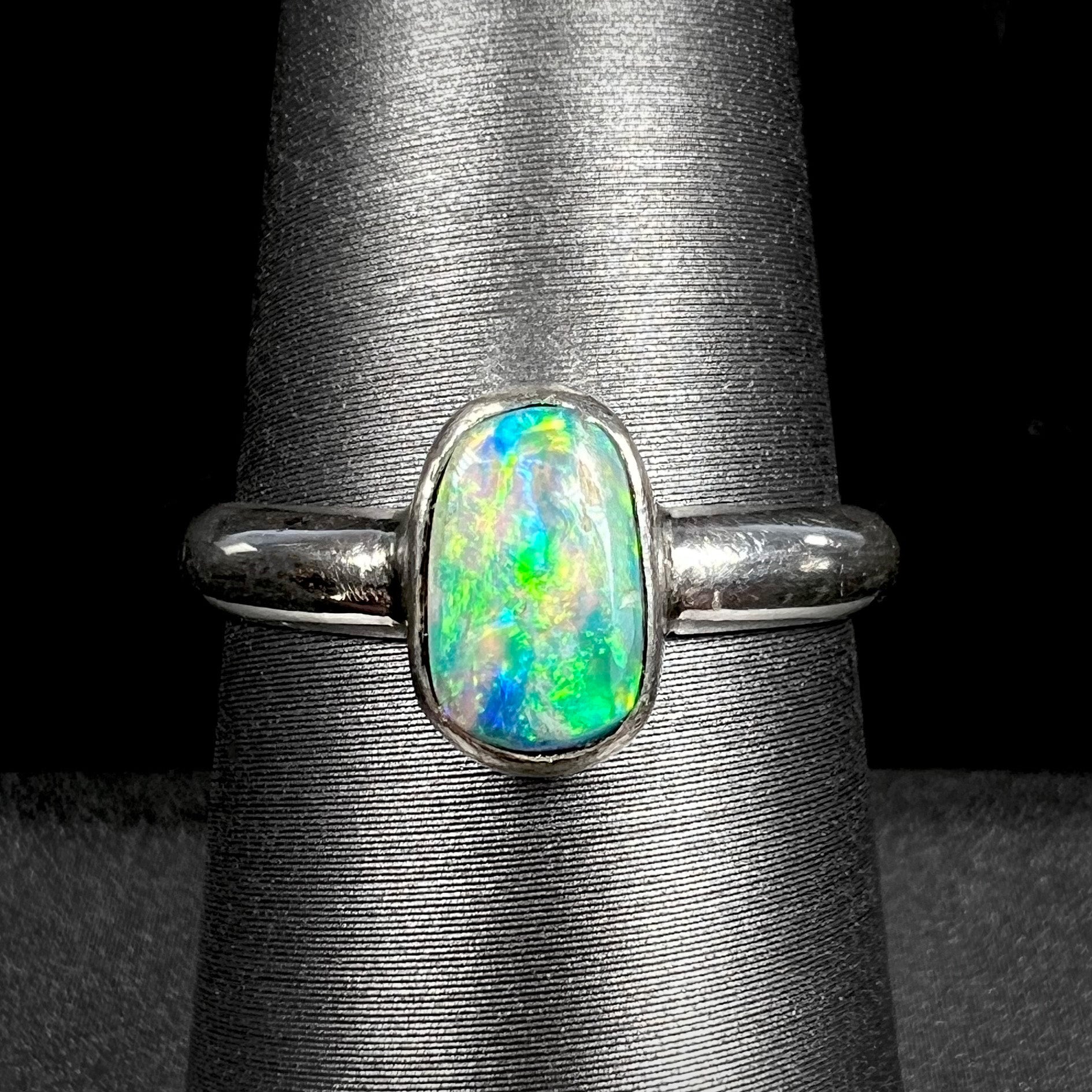 Handmade silver Australian crystal opal solitaire ring shown close-up on ring display