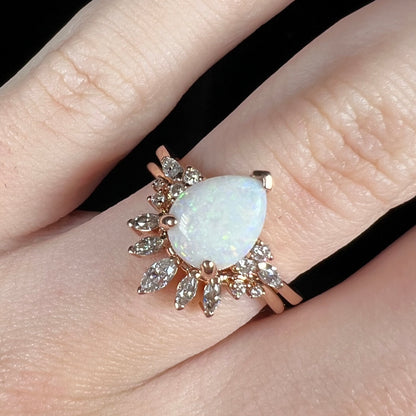 Close-up of stacking Australian white opal and moissanite wedding ring set in rose gold on finger
