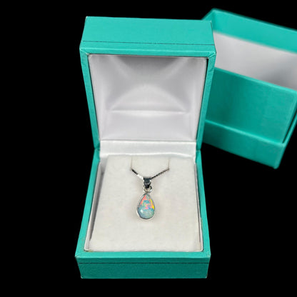 A dainty, sterling silver necklace bezel set with a natural, pear shaped opal stone.