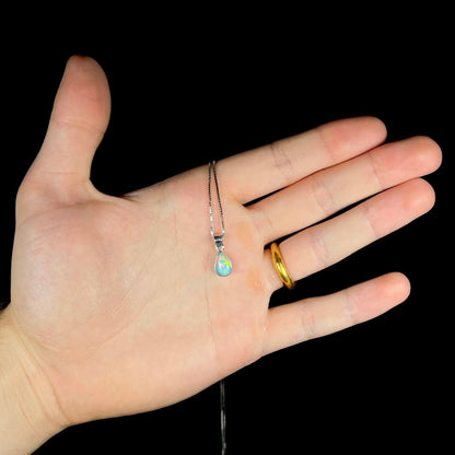 A dainty, sterling silver necklace bezel set with a natural, pear shaped opal stone.