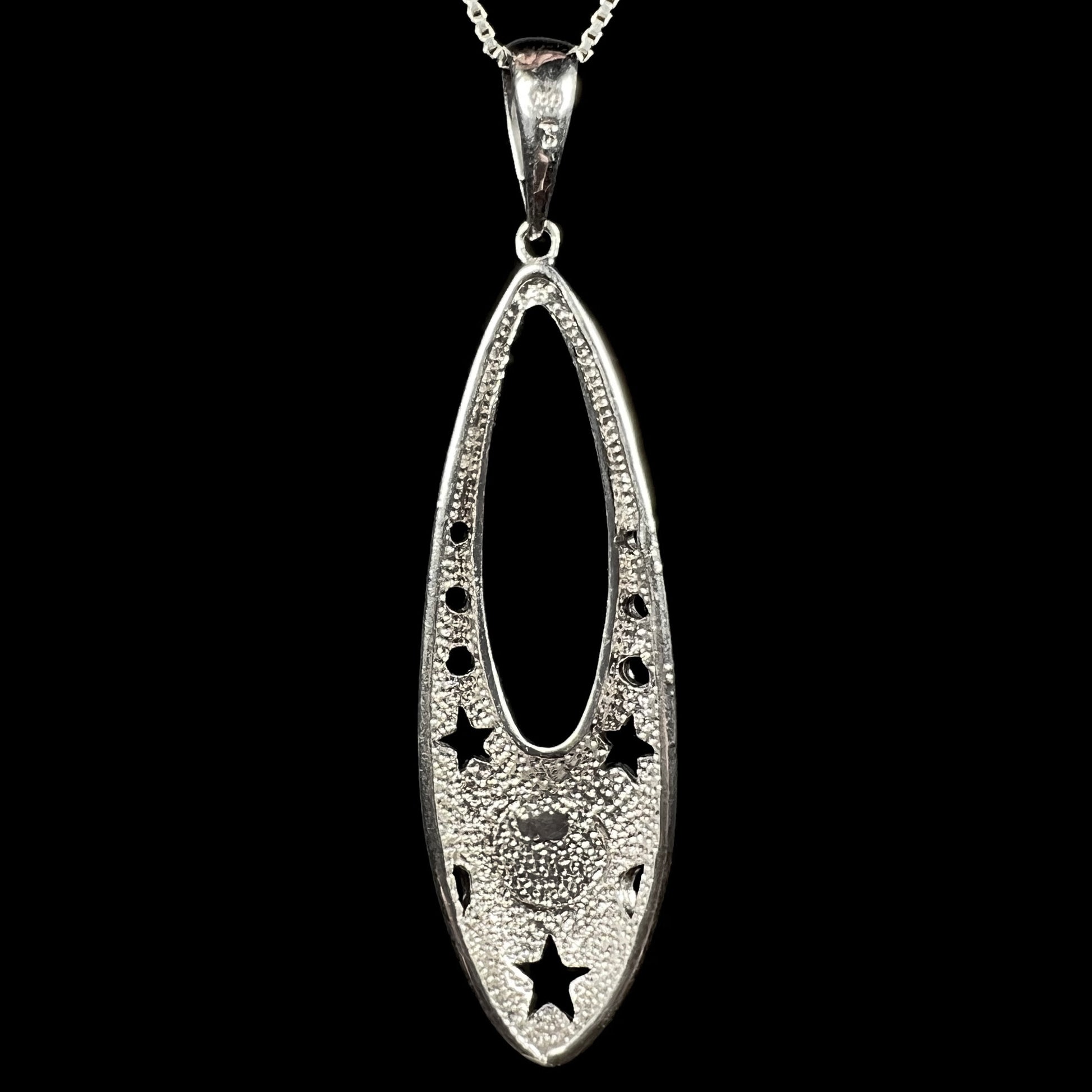 Back side of a sterling silver ballerina shoe pendant, shown against a black background.