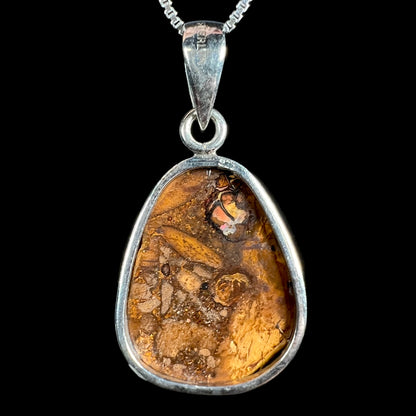 Back side of a sterling silver Australian boulder opal pendant, shown against a black background.