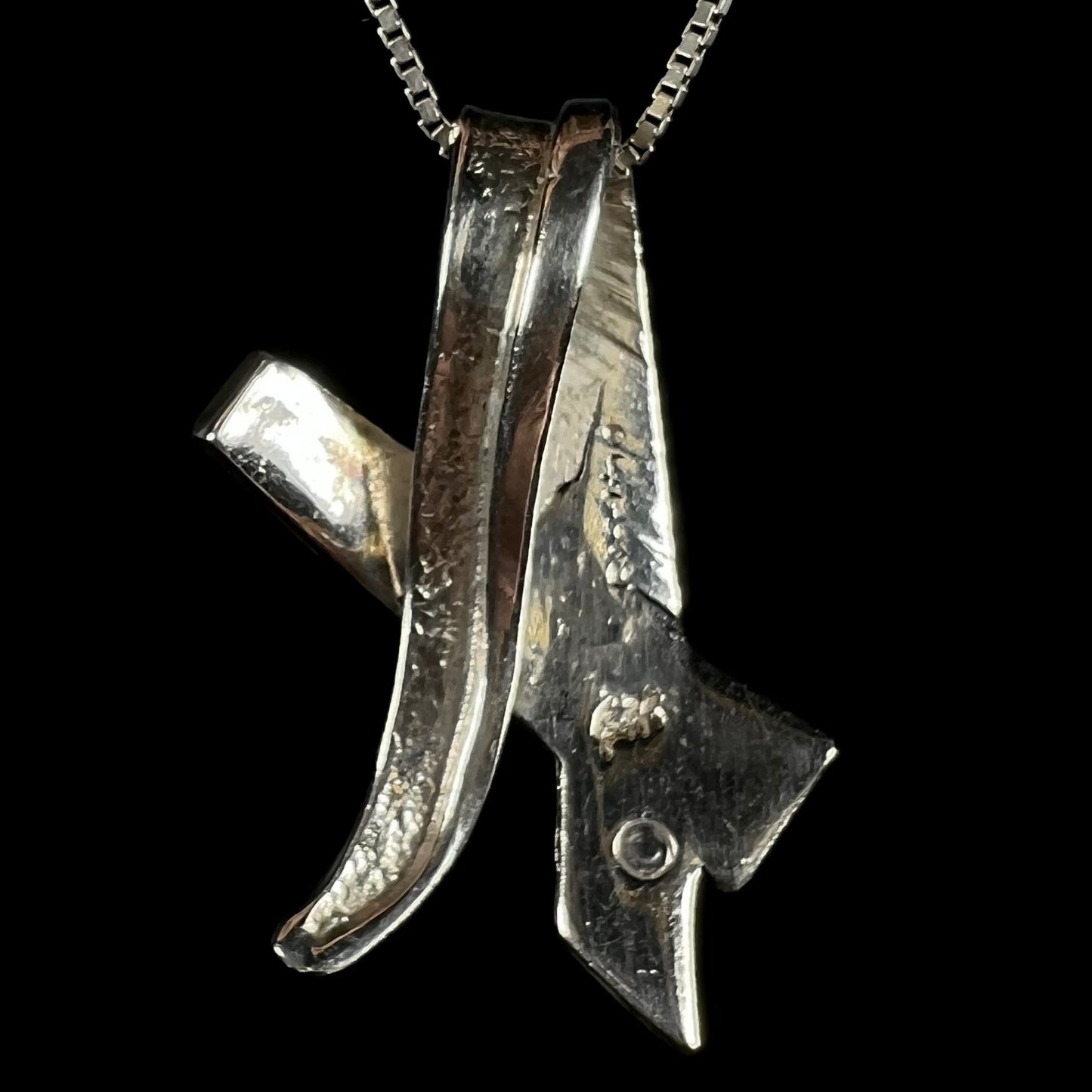 Back side of a folded design sterling silver pendant.