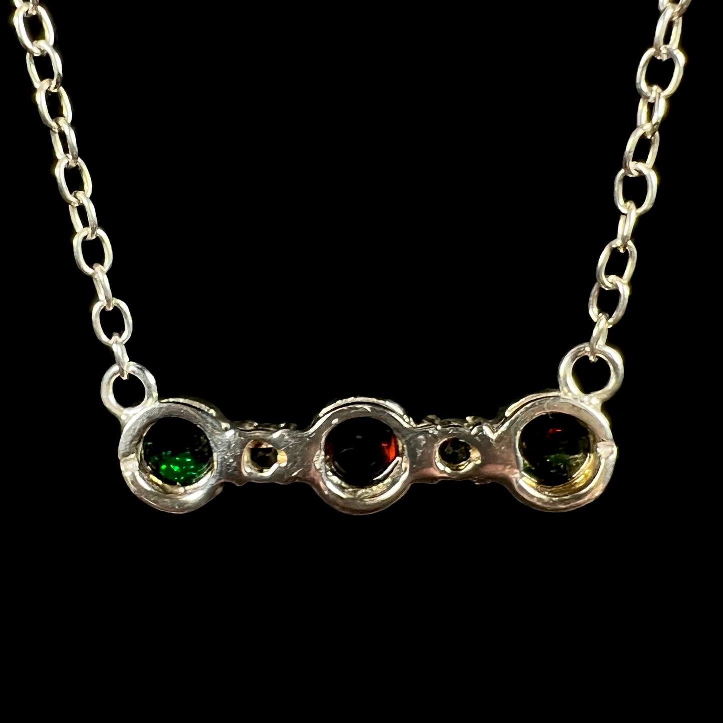 Back side of a three-stone black Ethiopian opal necklace in sterling silver.
