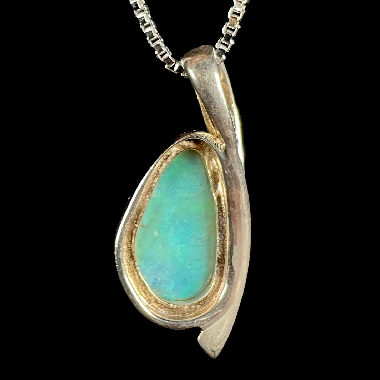 Back side of a green Australian crystal opal necklace in sterling silver, shown against a black background.