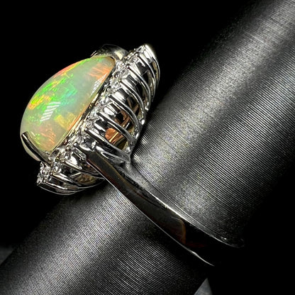 Side profile view of a basket set Ethiopian opal and diamond halo ring, focused on the ring's 18k white gold shank.