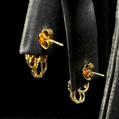 Back side of Black Hills gold earrings on display showing butterfly backs and posts