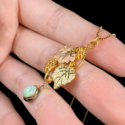 Side-angled view of a Black Hills gold opal necklace against a black background, capturing the opal’s green flashes.