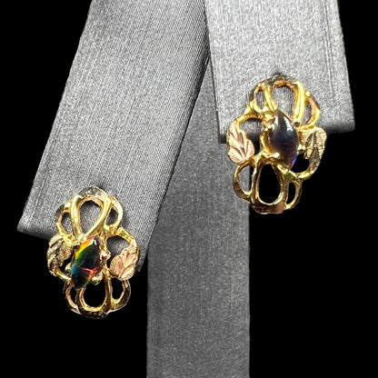 Pair of lab-created black opal black hills gold stud earrings on earring display