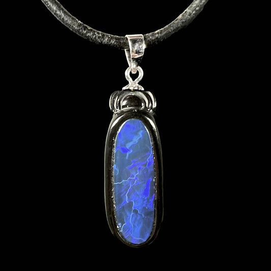 A Lightning Ridge black opal and onyx pendant displayed against a black background.