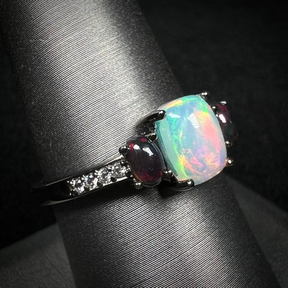 Ethiopian opal and CZ ring with black rhodium plated sterling silver finish on display