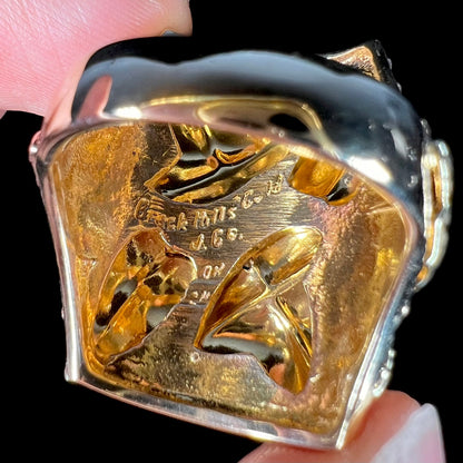 A men's solid gold ring.  The ring is Black Hills gold featuring a grapevine and leaf motif with rose and green gold designs.