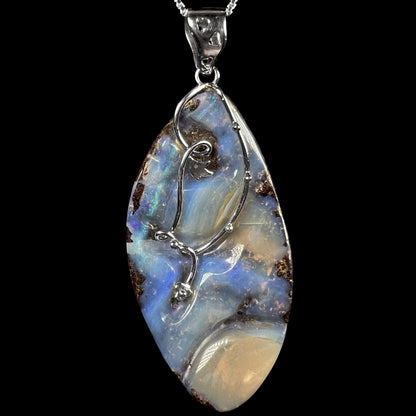 A large, blue Australian boulder opal necklace in sterling silver, shown close-up against a black background.