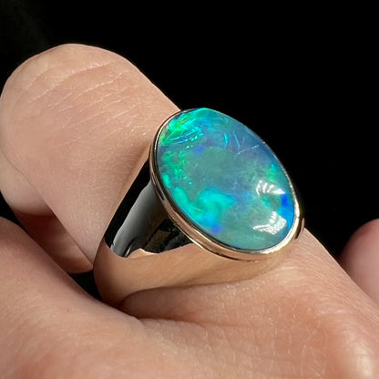 14k white gold blue Australian opal men's ring shown close-up on finger