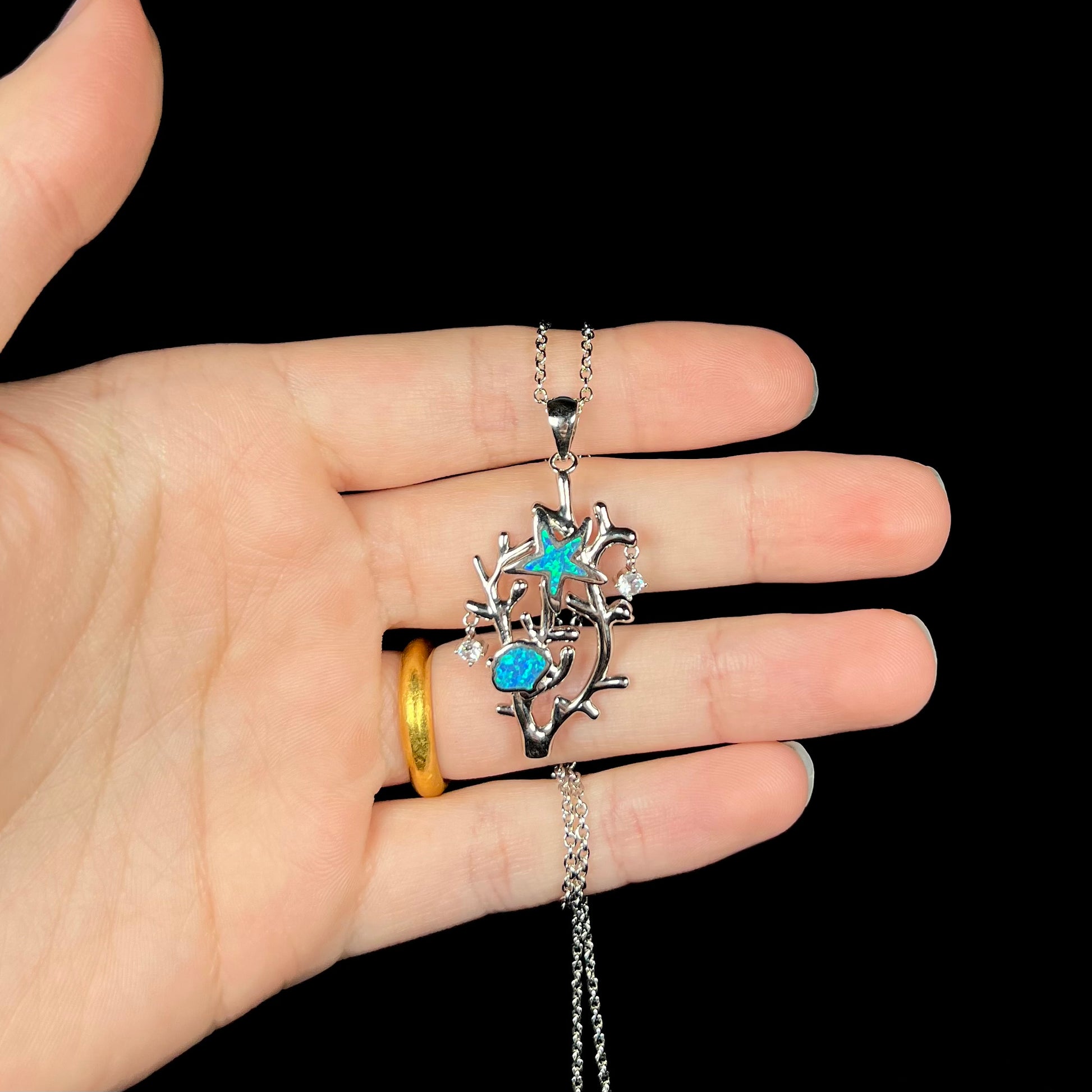 A silver plated coral reef necklace with blue lab-created opal inlay and CZ accents.