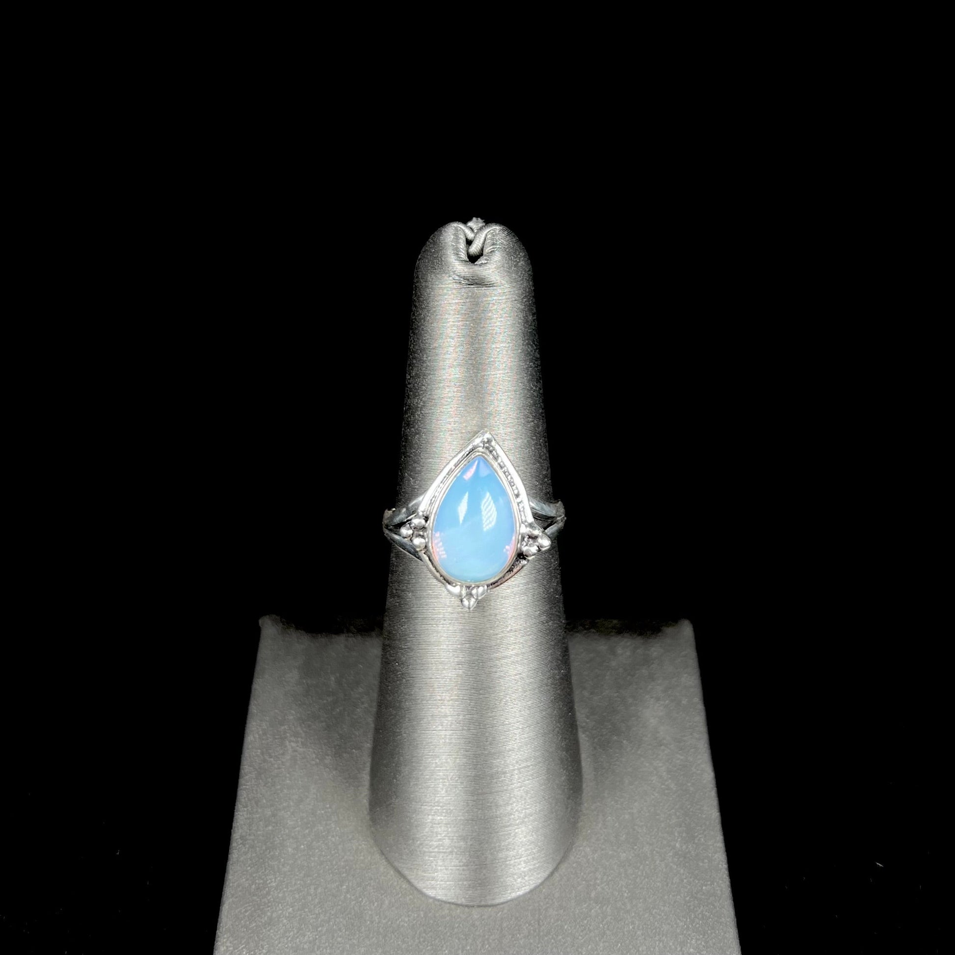 A handmade white metal ring set with a pear shaped opalite cabochon.