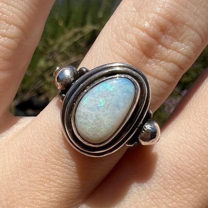 Close-up front view of a handmade Boho-style sterling silver opal ring set with an Australian opal in sunlight.