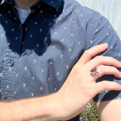Boho fire agate ring worn on shoulder with brown stone in sunlight.