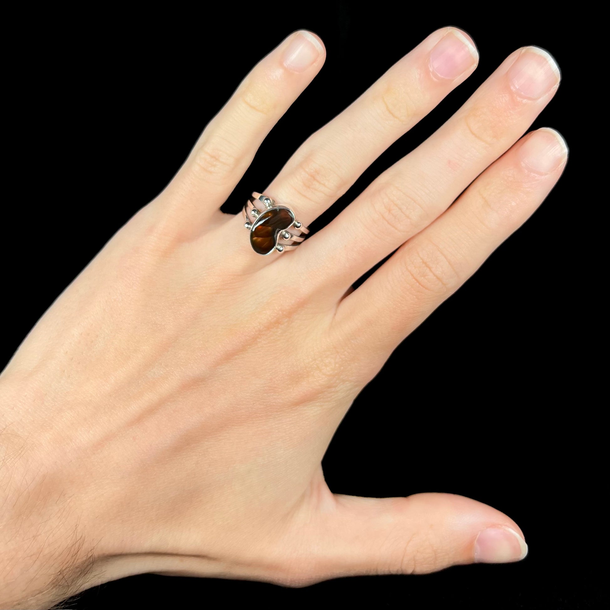 Mexican fire agate ring worn on hand with dark brown stone.