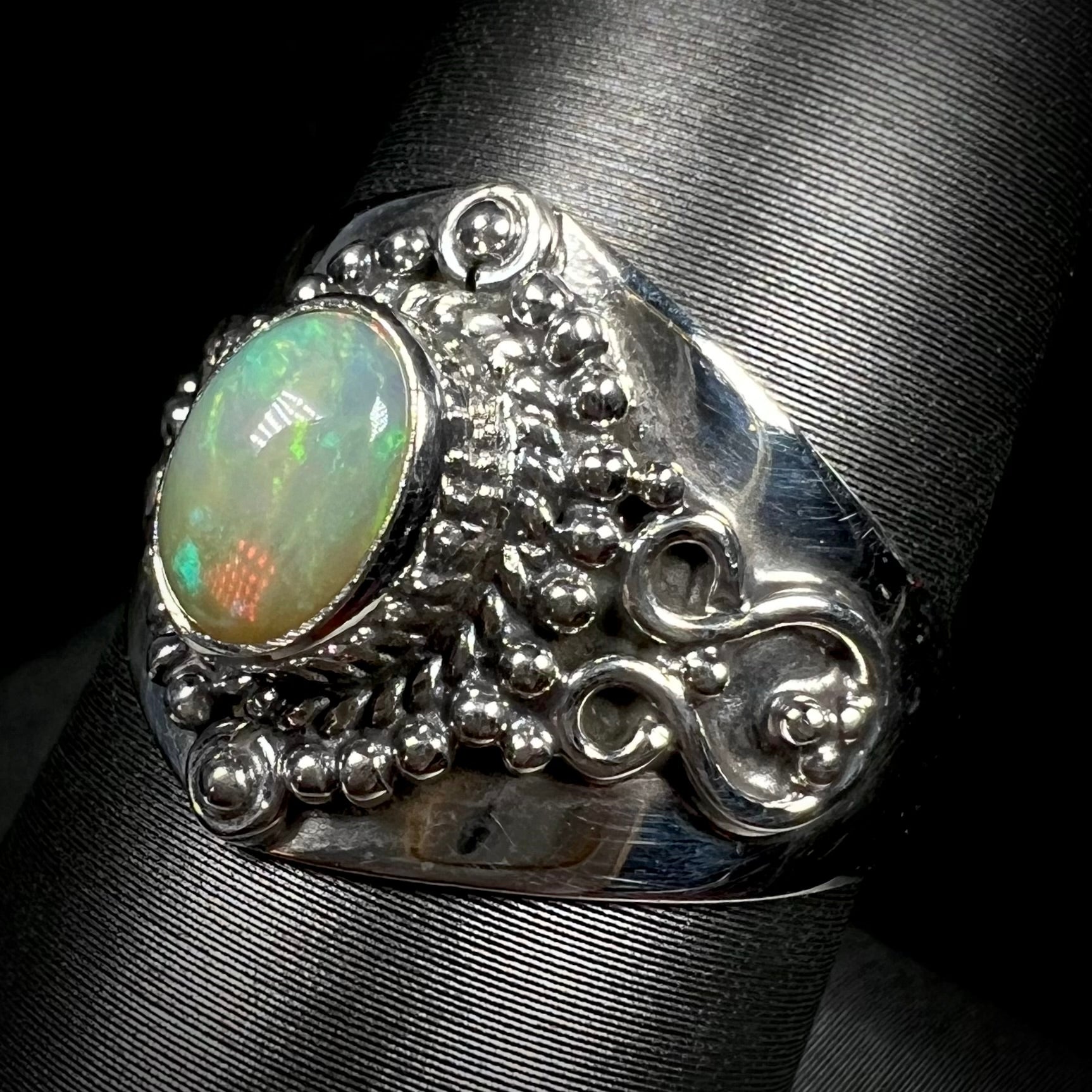A sterling silver, boho-style opal ring shown from an angle.
