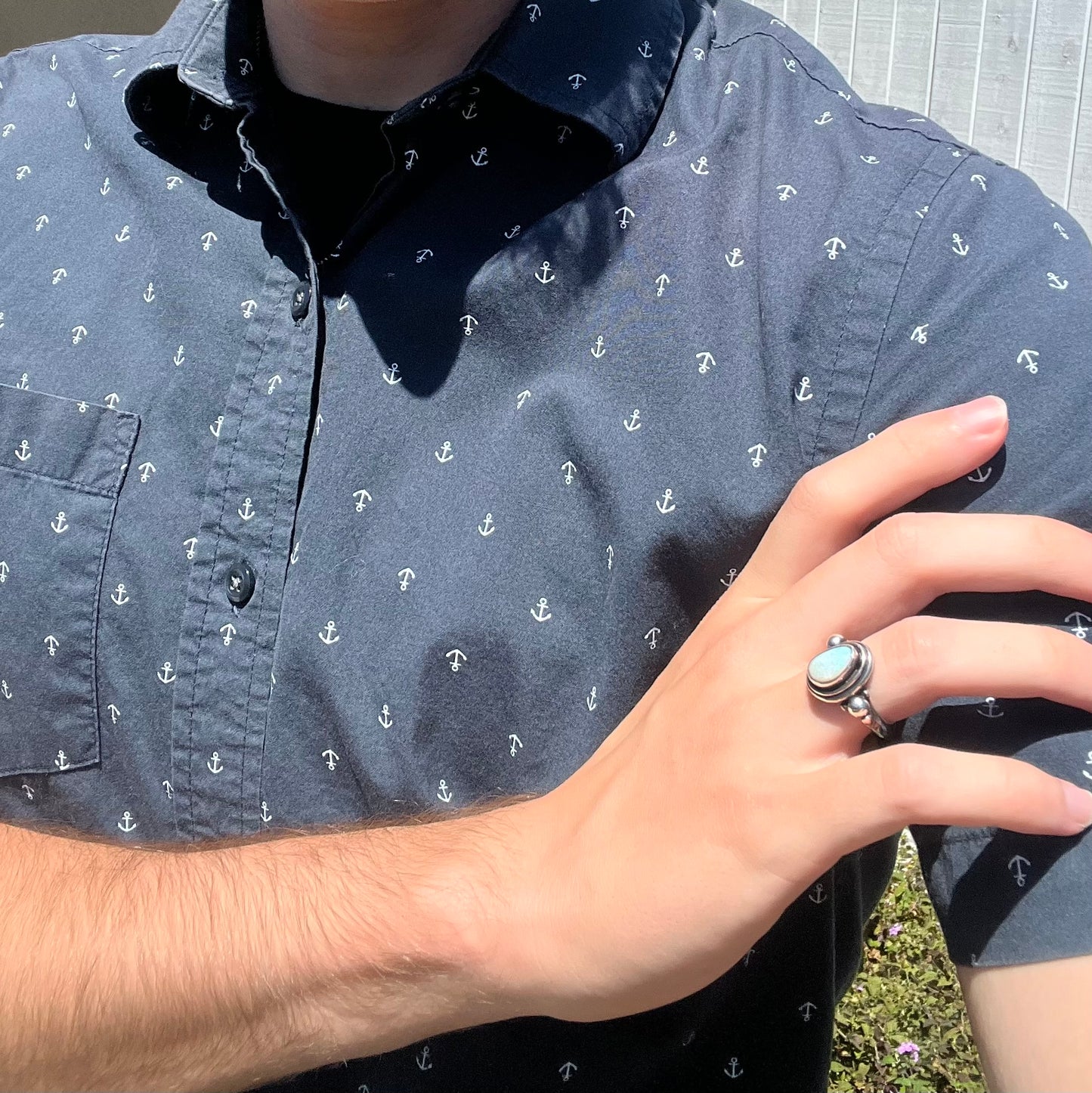 A silver Boho opal ring worn on a hand resting against the model's opposing shoulder.
