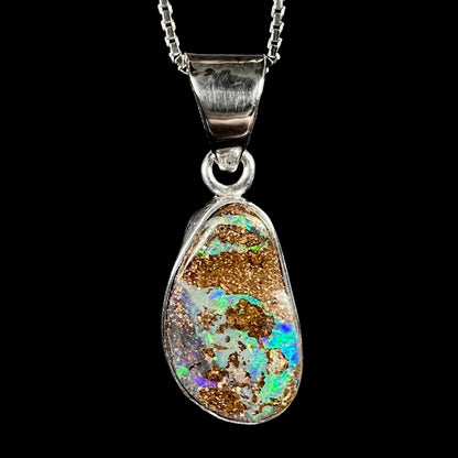 A sterling silver pendant set with an Australian boulder opal on a silver box chain.