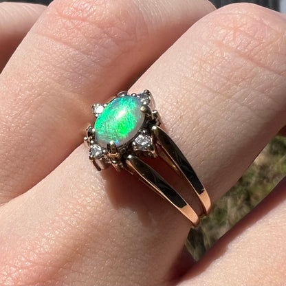 Bright blue-green flash of color seen in gold Australian opal and diamond flip ring, worn on hand under sunlight