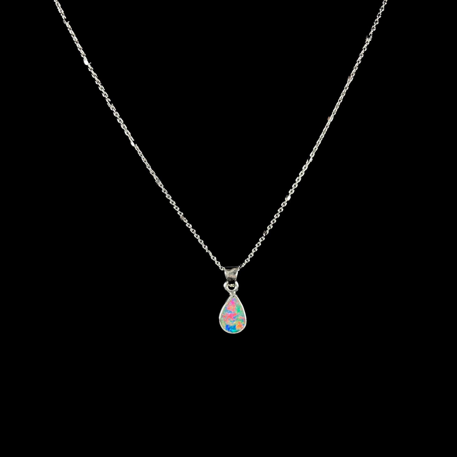 A pear shaped black opal necklace set in sterling silver.  The opal vividly flashes every color of the rainbow.