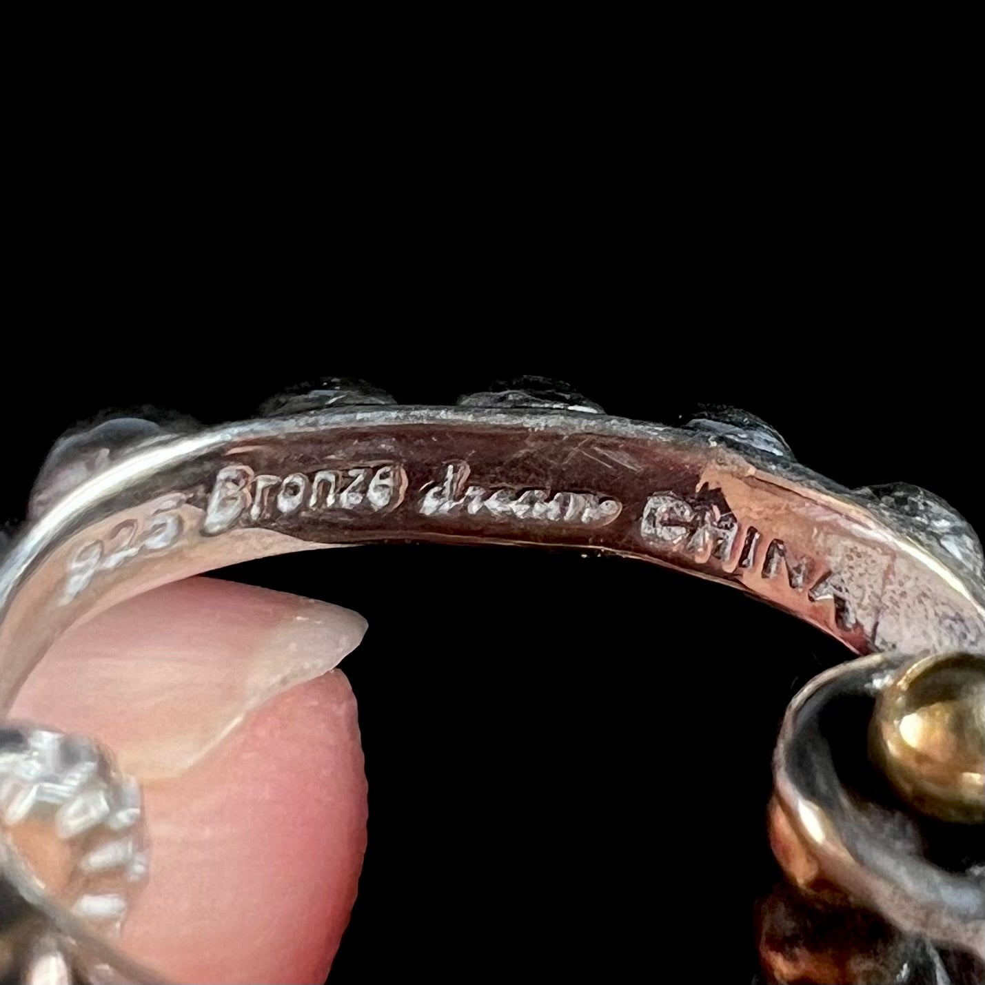 Inside of a sterling silver pendant bail, hallmarked "925", "Bronze", "dream", and "CHINA".