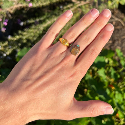 A freeform pear shaped Royston turquoise stone.  The stone is predominantly brown matrix with green turquoise around the edges.