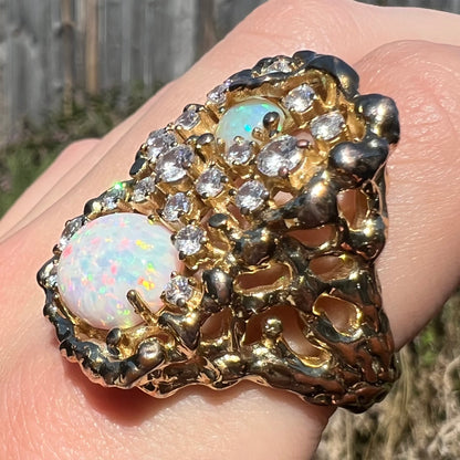 Angled close-up view of a brutalist lab-created opal men's costume ring showing the organic shank, worn on finger in natural light.