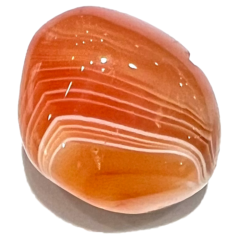 A tumbled carnelian agate stone.  White banded stripes run horizontally through the orange bodycolor.