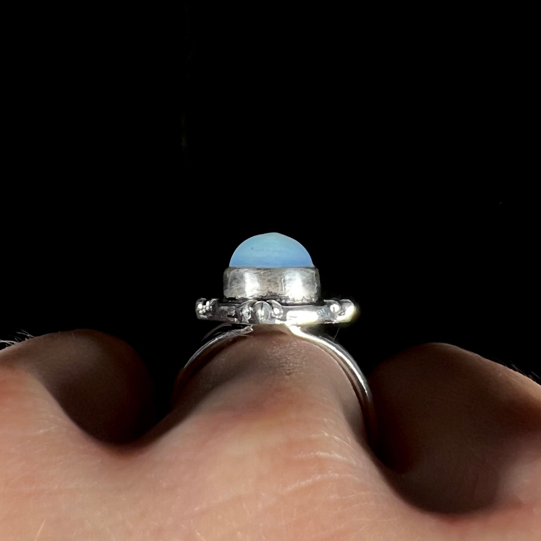 A handmade white metal ring set with a pear shaped opalite cabochon.