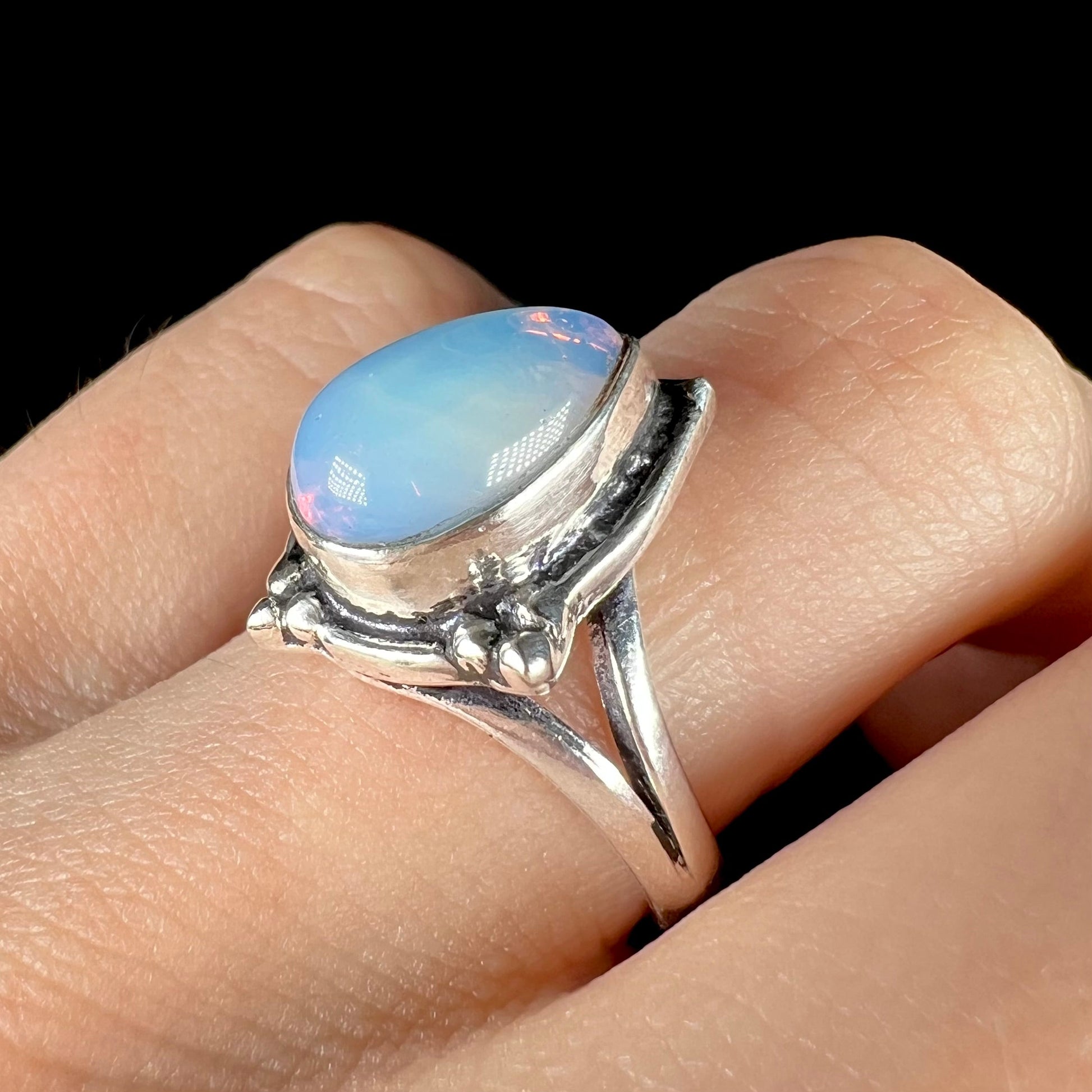 A handmade white metal ring set with a pear shaped opalite cabochon.