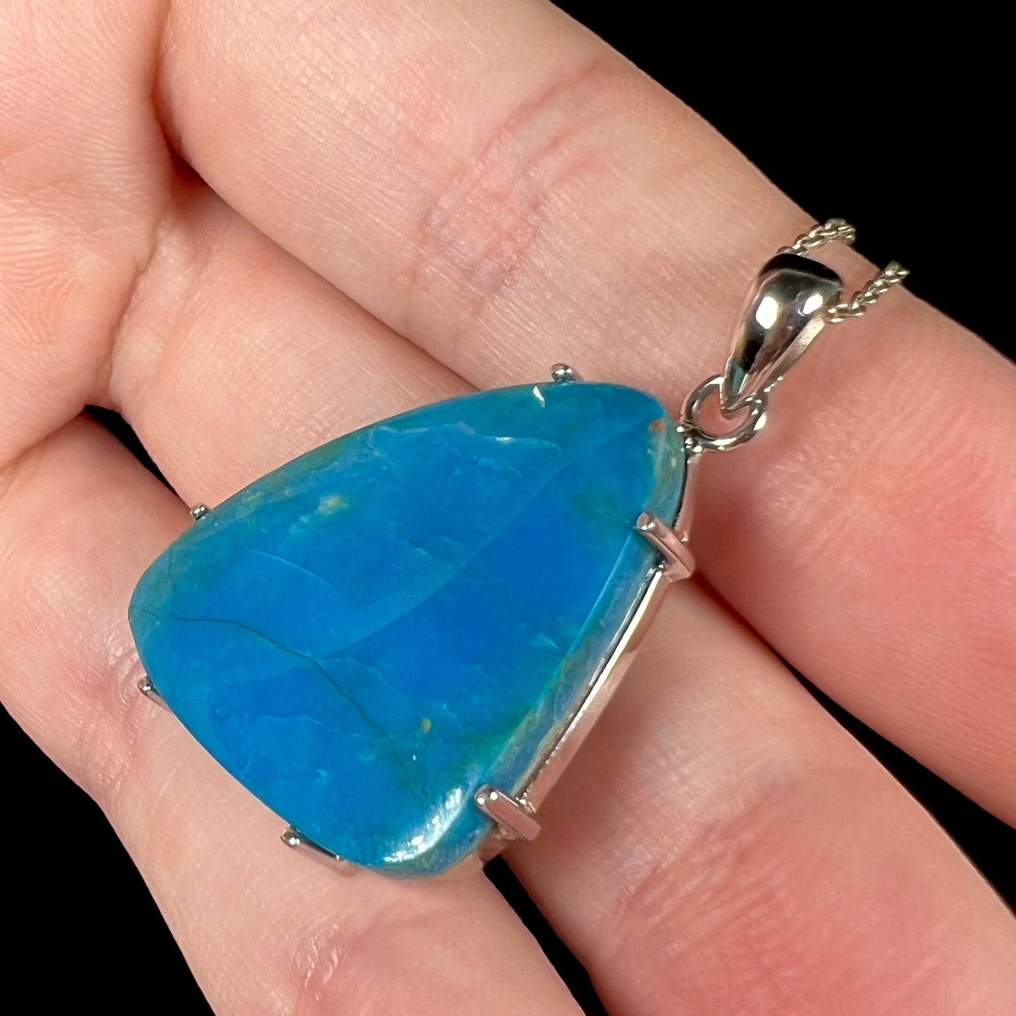 A side-angle view of a Chilean blue opal necklace in sterling silver, showcasing the setting.