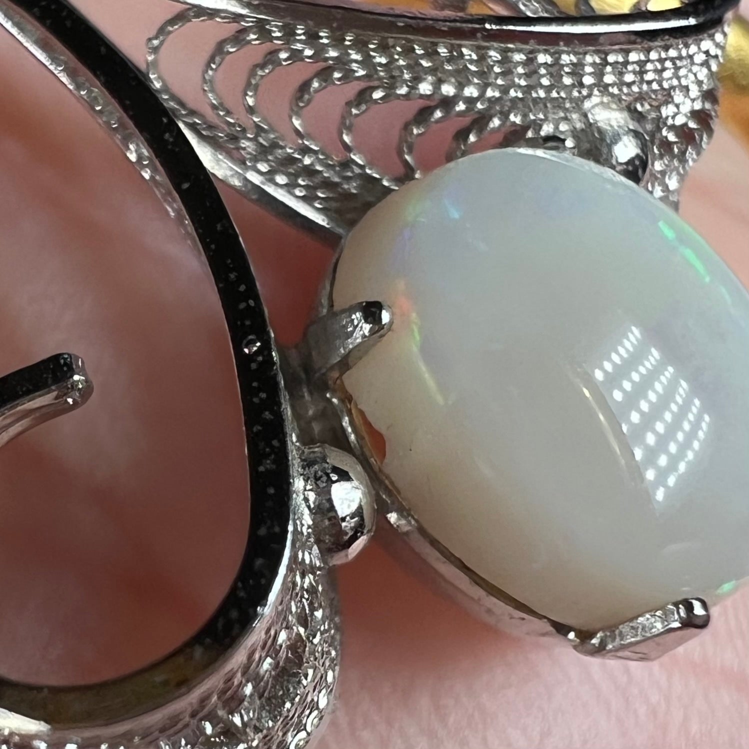 Close-up view of a chipped white Australian opal set in a Sorrento brand sterling silver pendant.