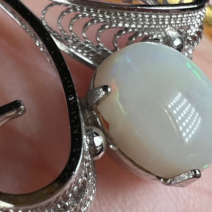 Close-up view of a chipped white Australian opal set in a Sorrento brand sterling silver pendant.