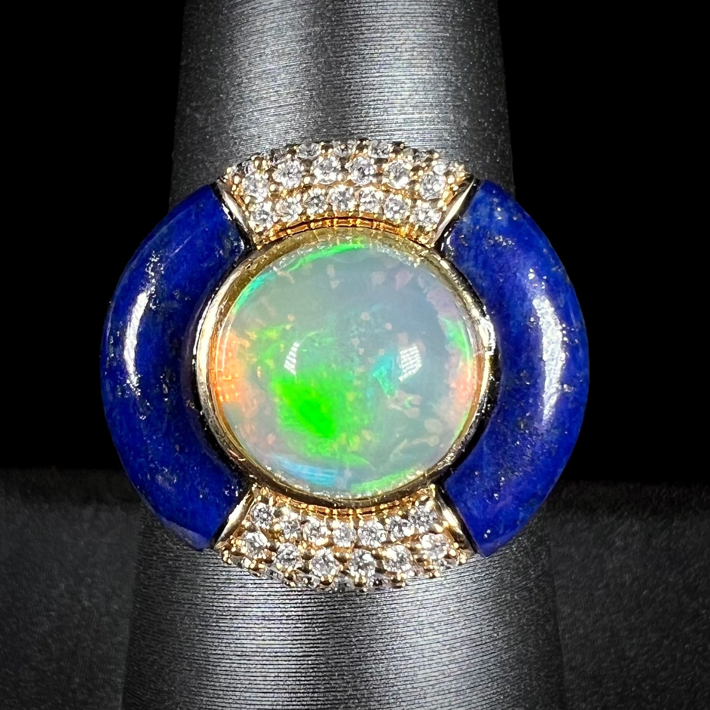 Front close-up macro view of a round Ethiopian opal and lapis lazuli with diamond halo design ring in 14k yellow gold, made by designer Cirari.