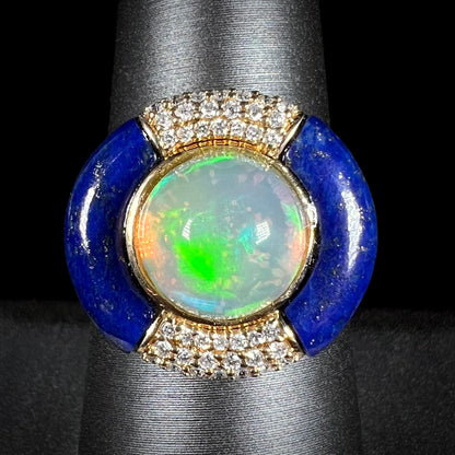 Front close-up macro view of a round Ethiopian opal and lapis lazuli with diamond halo design ring in 14k yellow gold, made by designer Cirari.