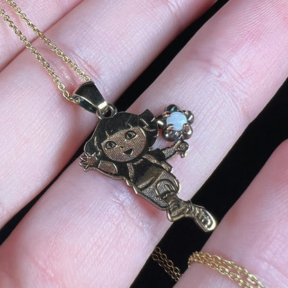 Angled view of official Dora the Explorer opal necklace held in a hand, licensed by Nickelodeon to Jacmel.