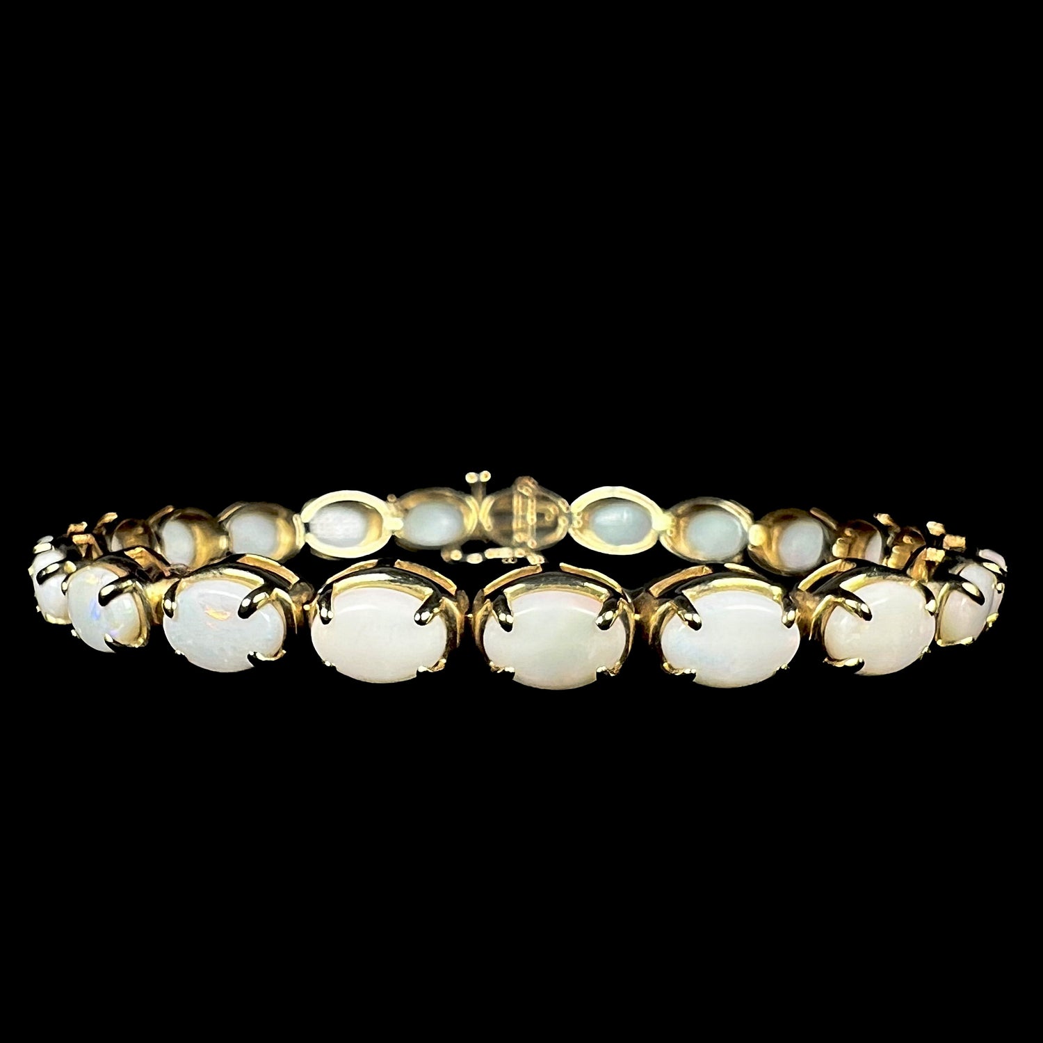 Front view of women's 7.5 inch 10k yellow gold tennis bracelet set with 21 Coober Pedy, Australian white opals.