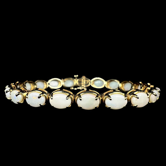 Front view of women's 7.5 inch 10k yellow gold tennis bracelet set with 21 Coober Pedy, Australian white opals.
