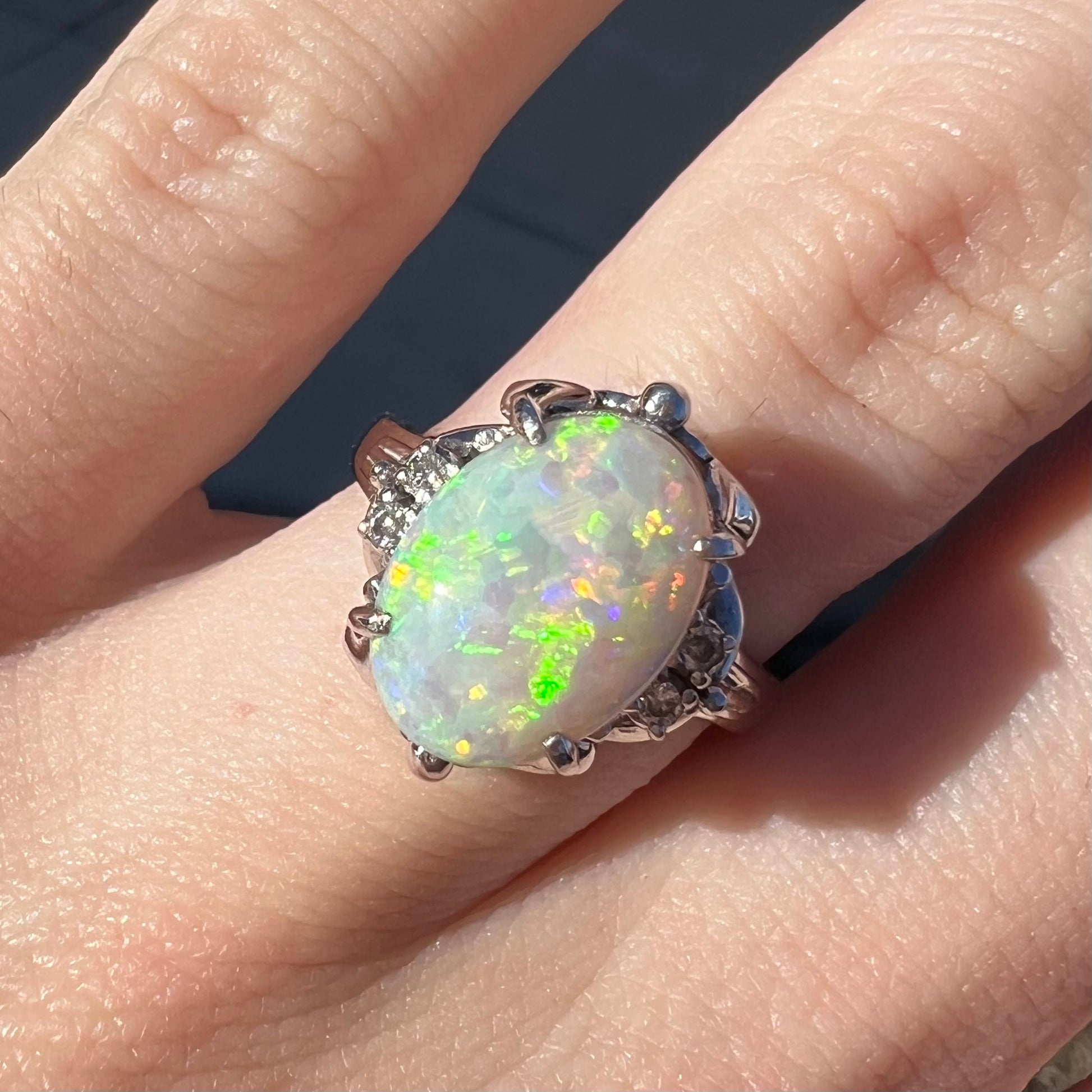 A Japanese-style platinum ring mounted with a Coober Pedy opal and diamond accents.