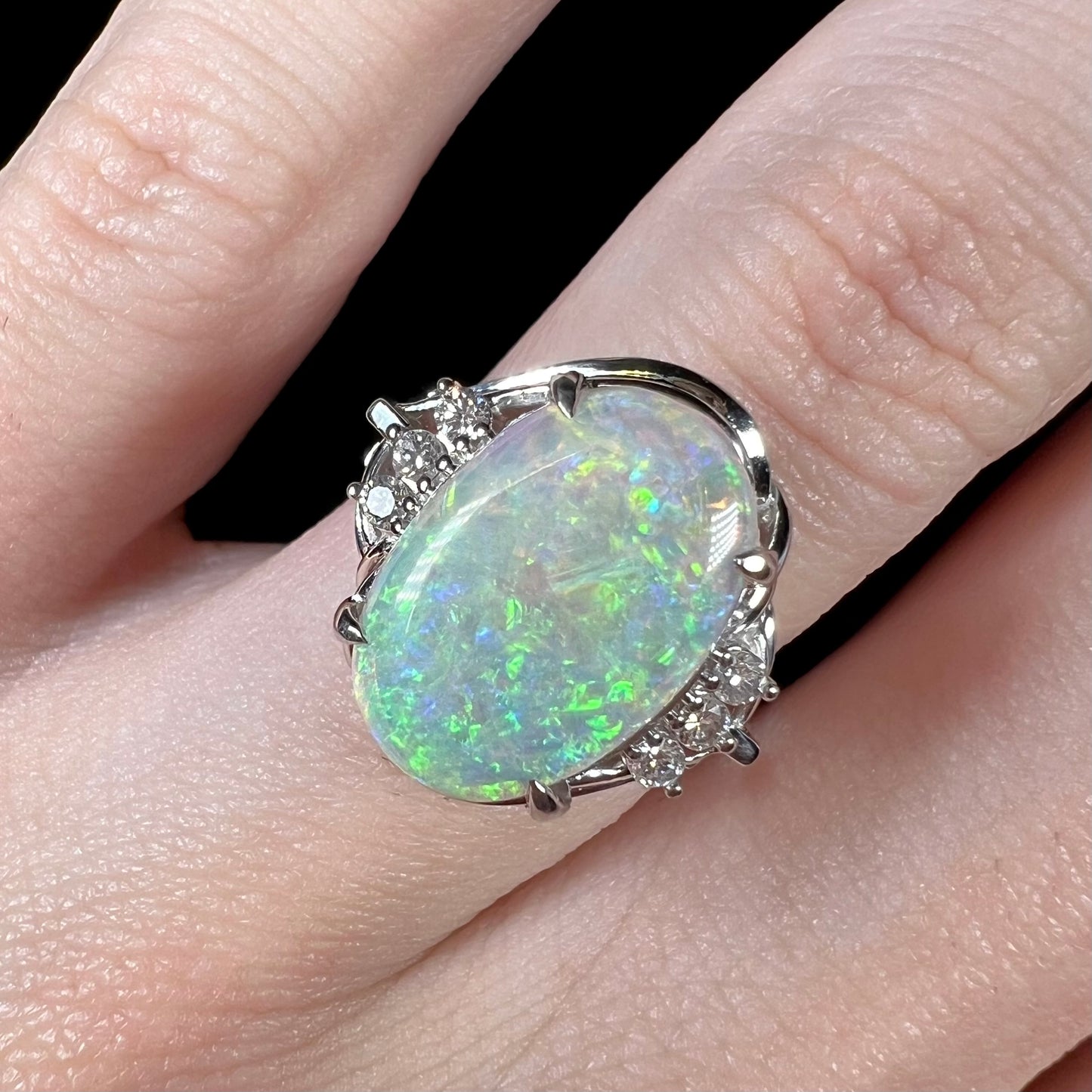 A platinum ring set with a 2.54ct Coober Pedy semi-crystal opal and diamond accents.