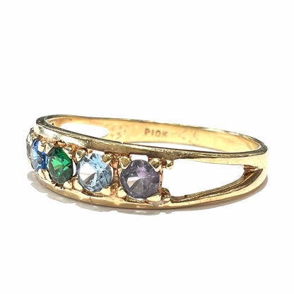 A ladies' yellow gold band set with green, dark blue, light blue, and light purple stones.