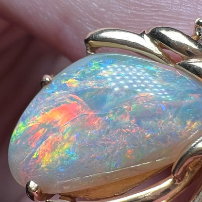 Close-up of a colorful, crazed Australian opal pendant, focusing on the opal's internal cracks caused by natural crazing.