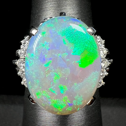 A platinum filigree ring set with a large, green-blue Mintabie crystal opal and diamonds.